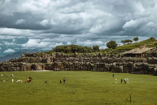 Sacsayhuaman en dia nublado con turistas alrededor